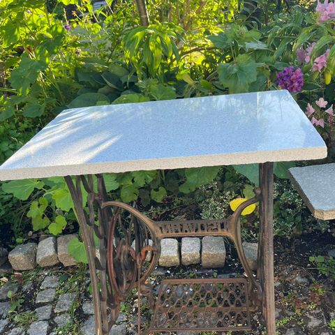 Pent og praktisk hagebord/terrassebord med hvit spettet steinplate.