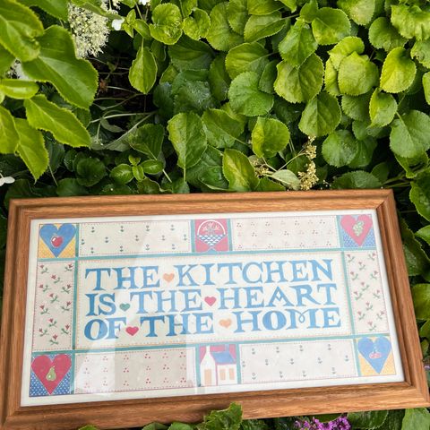 Trykk i eikeramme: The kitchen is the heart of the home. Fra USA ca 1990