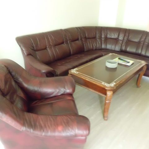 Buet sofa med stol i rødt skinn.