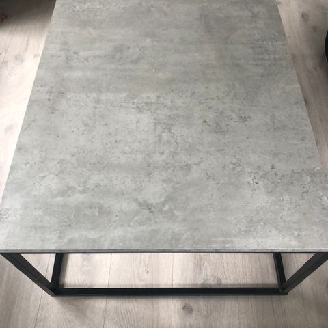 Stuebord med sort stålramme og grå betonglook plate