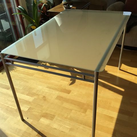 IKEA bord i stål og glass.