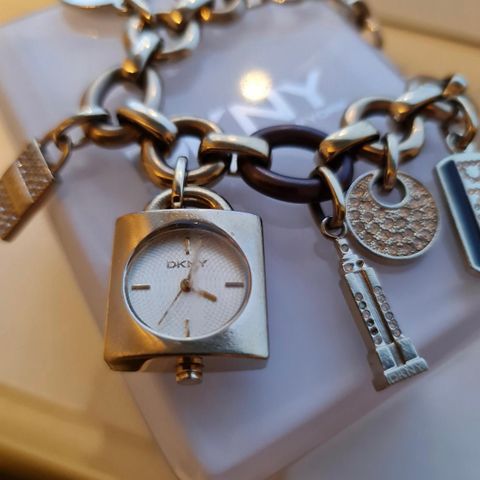 Nydelig DKNY klokkearmbånd med charms selges!