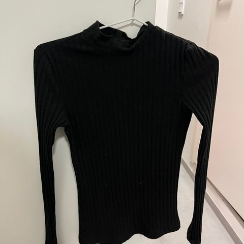 Selger svart tettsittende genser