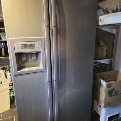 Side ved side kjøleskap og fryseskap med ismaskin og vann