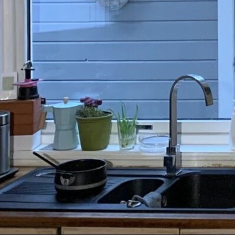 Sort granitt kjøkkenvask med kran
