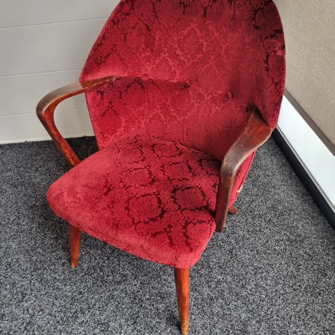 Gammel stol med armlene og rødt stoff til salgs