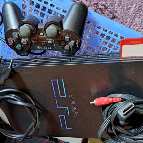 Playstation 2 med kontroller og spill.