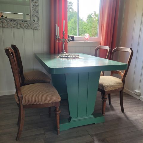 Spisestuebord med illeggsplater med 3 grønne stoler