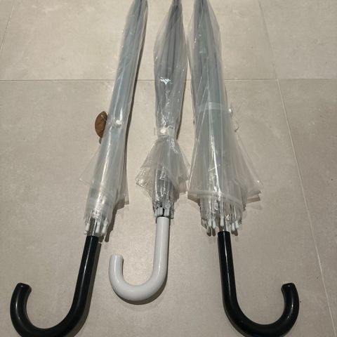 Tre gjennomsiktige paraplyer