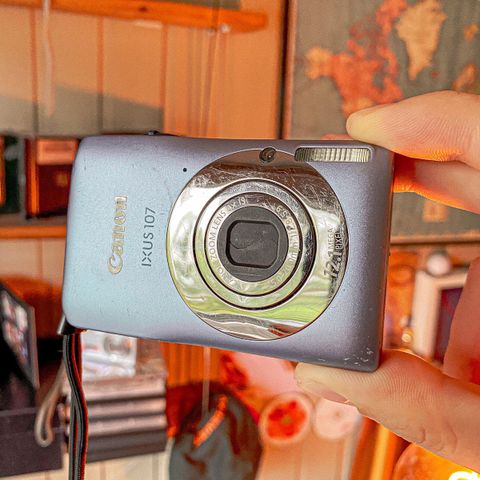 Liten lysblå Canon IXUS 107 kompakt kamera med lader