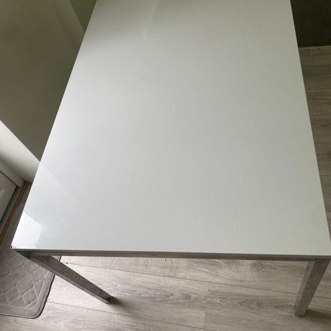 Hvit spisebord med metal ramme.