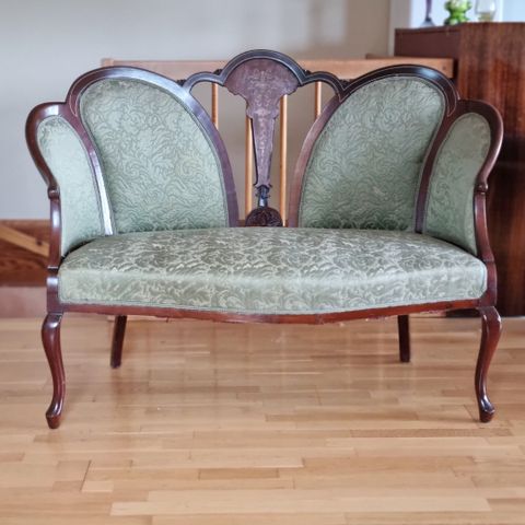 Liten antikk sofa i grønt brokadestoff. Edvardiansk stil