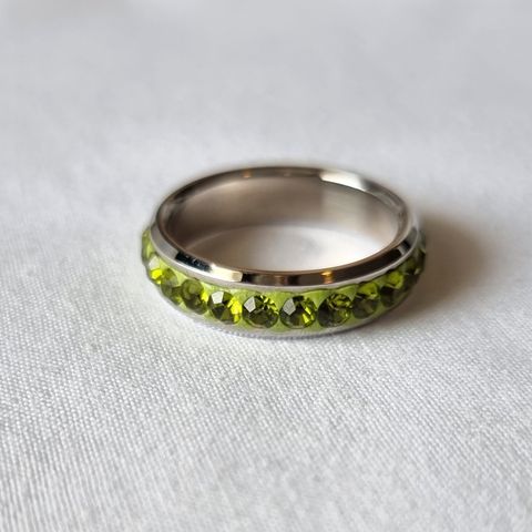 Fin ring i sølvfarget metall med grønne glitrende krystaller str 10