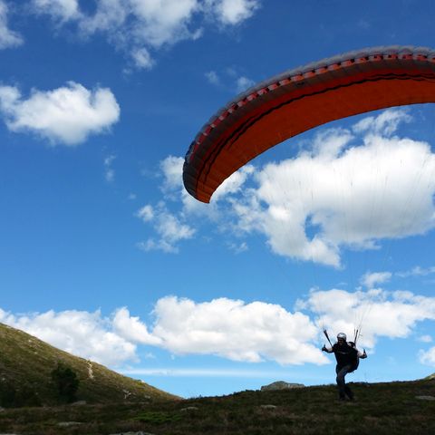 Paraglider med sele, nødskjerm, dress, hjelm og vario