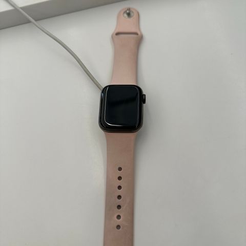 En pent brukt Apple Watch med rosa klokke reim