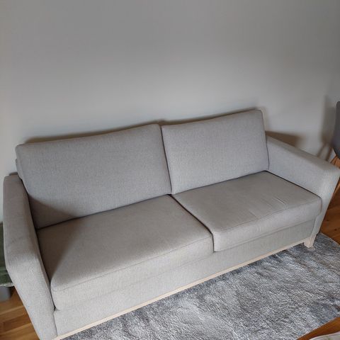 Lys grå sofa.