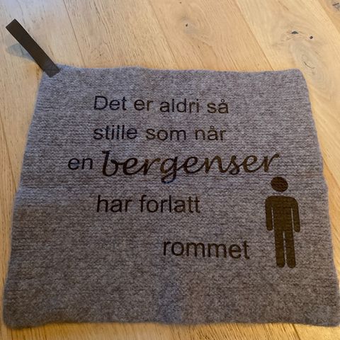 Sitteunderlag med tekst og hank