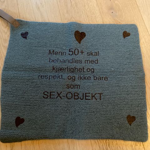 Sitteunderlag med tekst og hank