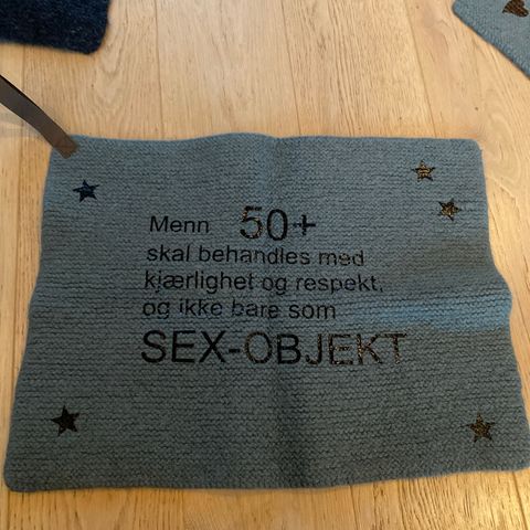 Sitteunderlag med tekst og hank