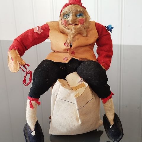 Gammel håndlaget Nisse - Julenise sitter på stubbe