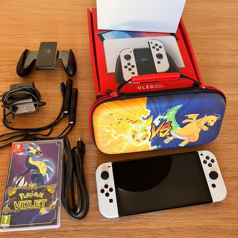 Nintendo Switch Oled sammen med Pokemon Violet spill og Pokemon case