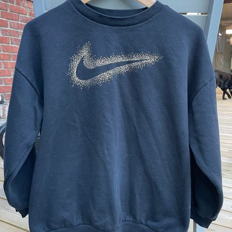 Nike genser med logo rammet inn i «gullstøv»