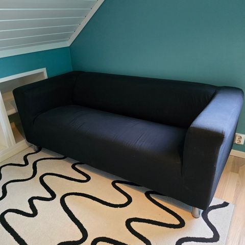 Klippan sofa fra Ikea, svart stoff. Følger med et ekstra trekk i rødt stoff.