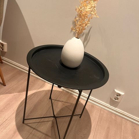 Sidebord med hvite vase og tørkede grener.