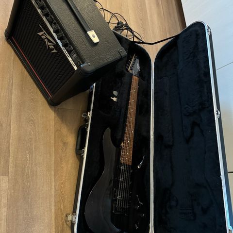 El-gitar med forsterker og gitarkasse.