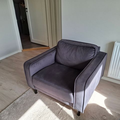 Mørk grå velur sofa stol.