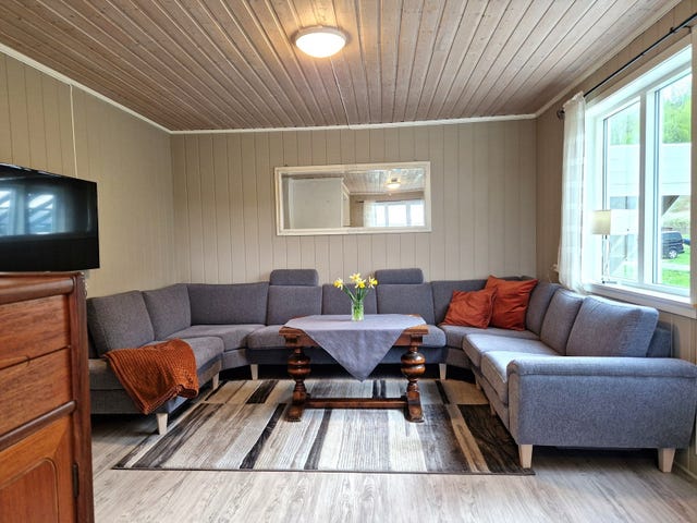 Stua er vinklet og har plass til flere sittegrupper. I dette hjørnet har eier naturlig plassert salongen med TV-krok. Vedovn er montert, og du har utgang til en stor terrasse.