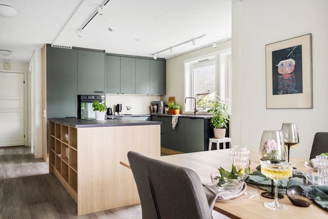 Innredningen er lekker, med en miks av fronter i matt skogsgrønn farge, håndtak i sort og skrog i eikefarget materiale. Her har du meget god plass til kopper og kar, så vel som gode arbeidssoner.