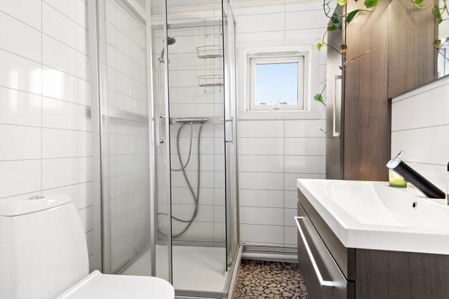Badet ligger plassert i andre etasje sammen med soverommene. Badet er lyst og har dusjkabinett, toalett og innredning.