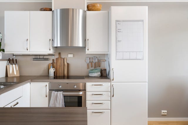Innredning med lakkerte fronter og laminert benkeplate. Tokummers vask med avrenningsrist i benkeplaten.