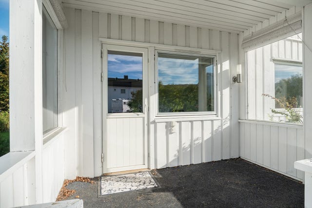 Takoverbygd terrasse med trapp mot plenområde.