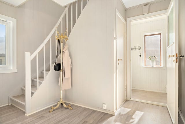 Fra yttergangen kommer du inn i en romslig hall som gir adkomst til både 2. etasje og kjeller før du kommer videre inn i boligens oppholdsrom.