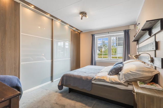 Soverommet har en romslig, plassbygget skyvedørsgarderobe med integrert belysning og god oppbevaringsplass. En praktisk løsning som utnytter
