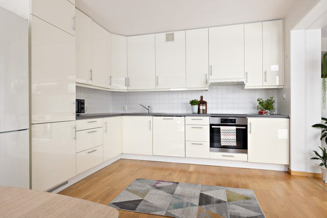 Kjøkkeninnredning av laminerte skrog med laminerte slette fronter, laminert benkeplate med nedfelt oppvaskkum i stål med ett-greps blandebatteri.
