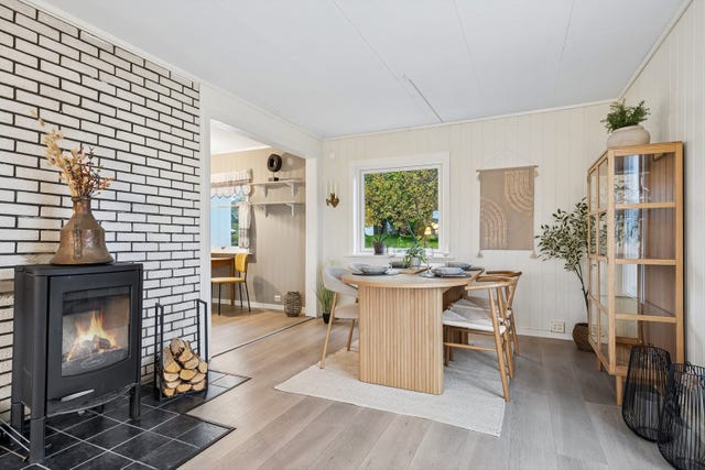 Stuen er delt opp i flere soner og spisestuen er praktisk plassert ved kjøkken.