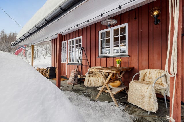 Rundt hytta er det opparbeidet utearealer med steinsatt inngangsparti og overbygd terrasse langs deler av fasaden.
