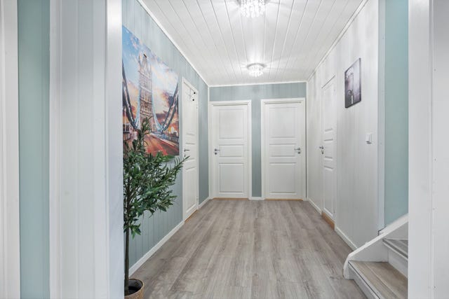 Romlig hall i 1.etasje som leder videre til soverom, walk-in garderobe og badet.