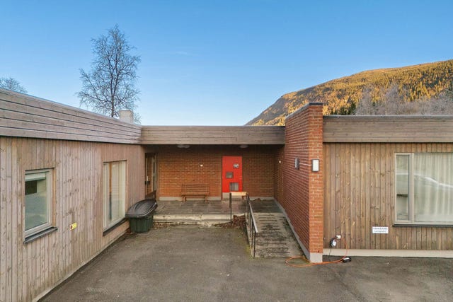 Leiligheten ligger inn døren på bildet. Det følger med en biloppstillingsplass.