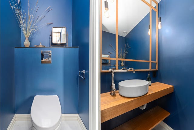 Toalettrommet har veggmontert klosett og servant rommet har flislagt gulv og varmekabler.