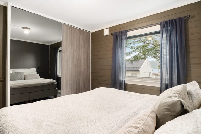 Det største soverommet et innredet med en praktisk skyvedørsgarderobe.