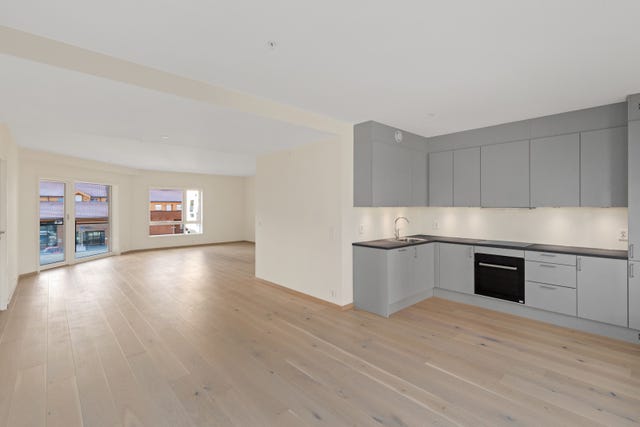 Kjøkkenet er moderne med glatte, lysgrå fronter for et pent og moderne inntrykk. Kjøkkenet byr på godt med skap og skuffeplass.