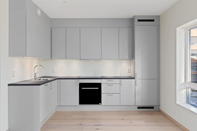 Kjøkkenet kan også by på stor benkeplate av laminat og integrerte hvitevarer som kjøleskap, platetopp, stekeovn og oppvaskmaskin.