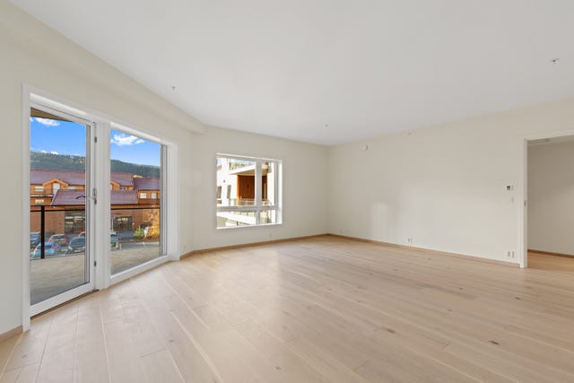 Rommet har rikelig med naturlig lys via vindusflater fra begge sider. God plass til både spisegruppe og sofagruppe, samt direkte adkomst til