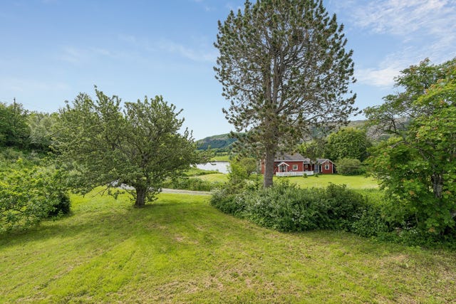 Eiendommen har en eiet tomt på ca. 1 453 m², opparbeidet med plen og beplantninger. Tomten er tilbaketrukket fra hovedveien og ligger lunt til for vær og vind.