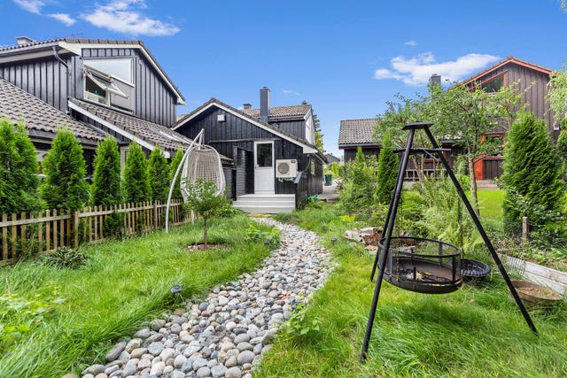Opparbeidet og pent beplantet hage på baksiden av huset.