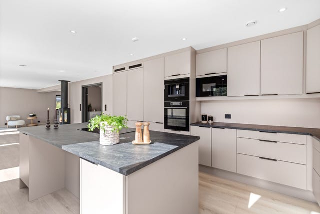 Kjøkkeninnredning med glatte fronter samt rikelig med skapplass.